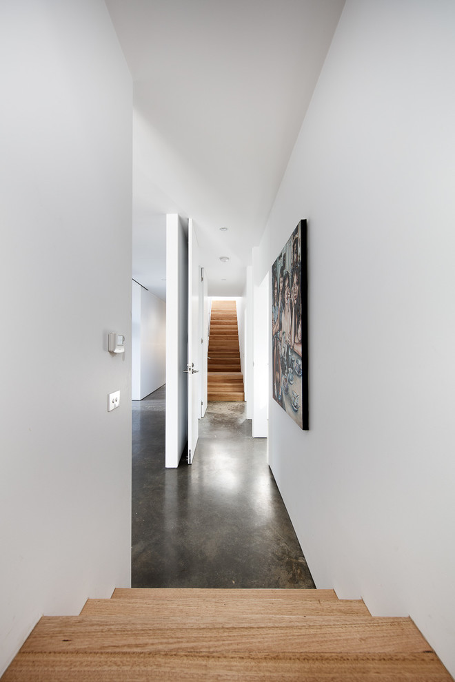 Photo of a mid-sized modern hallway in Melbourne with white walls and concrete floors.