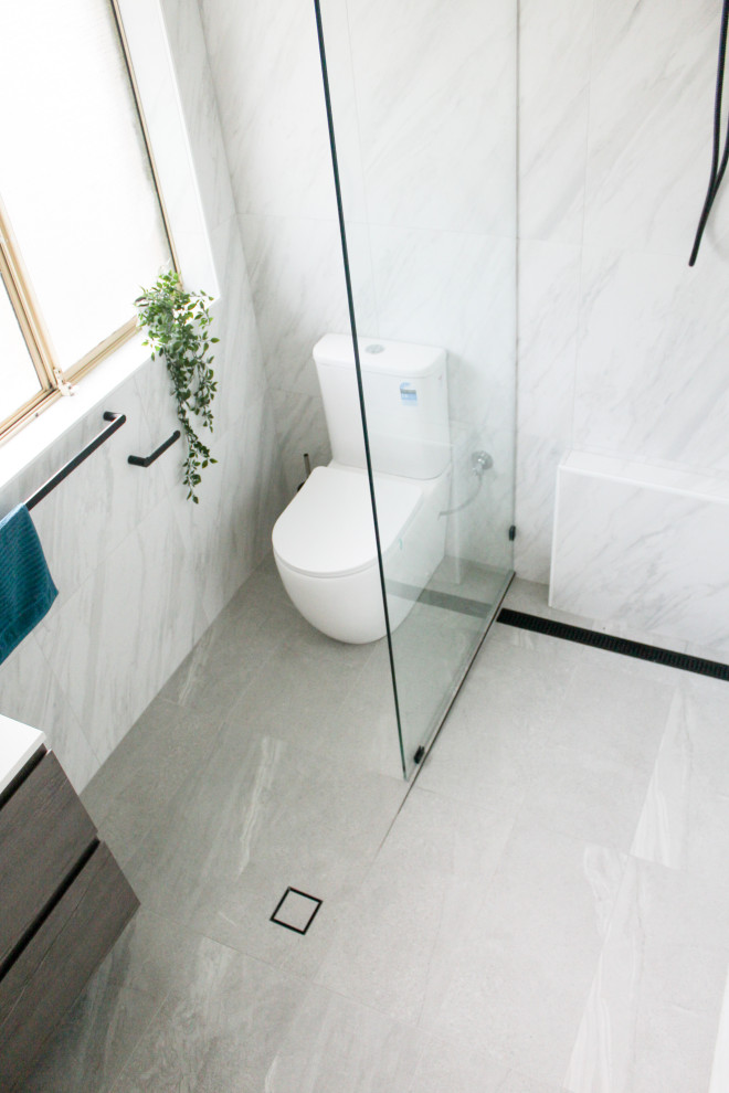 This is an example of a small modern master bathroom in Perth with flat-panel cabinets, white cabinets, an open shower, a one-piece toilet, white tile, porcelain tile, white walls, porcelain floors, a vessel sink, engineered quartz benchtops, grey floor, an open shower, white benchtops, a single vanity and a floating vanity.