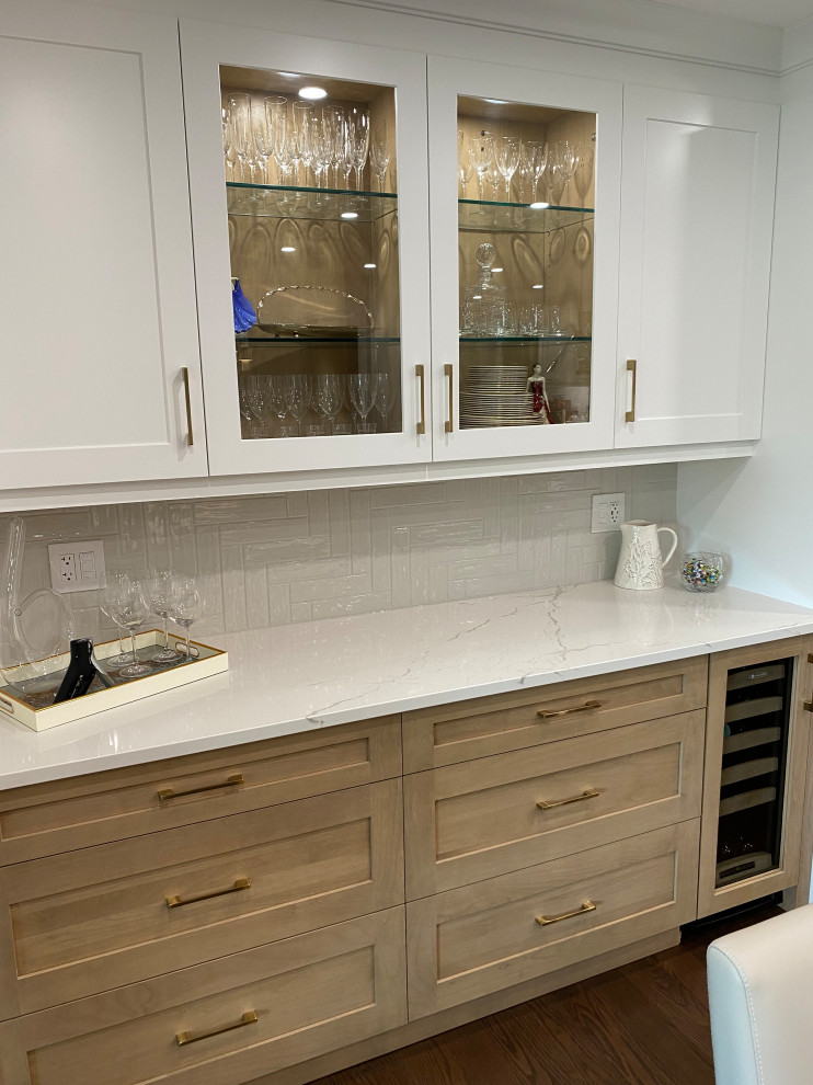 Inspiration for a mid-sized transitional l-shaped medium tone wood floor and brown floor eat-in kitchen remodel in Toronto with an undermount sink, shaker cabinets, white cabinets, quartz countertops, white backsplash, quartz backsplash, stainless steel appliances, an island and white countertops