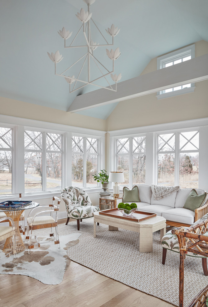Photo of a transitional sunroom in New York with light hardwood floors, a standard ceiling and beige floor.