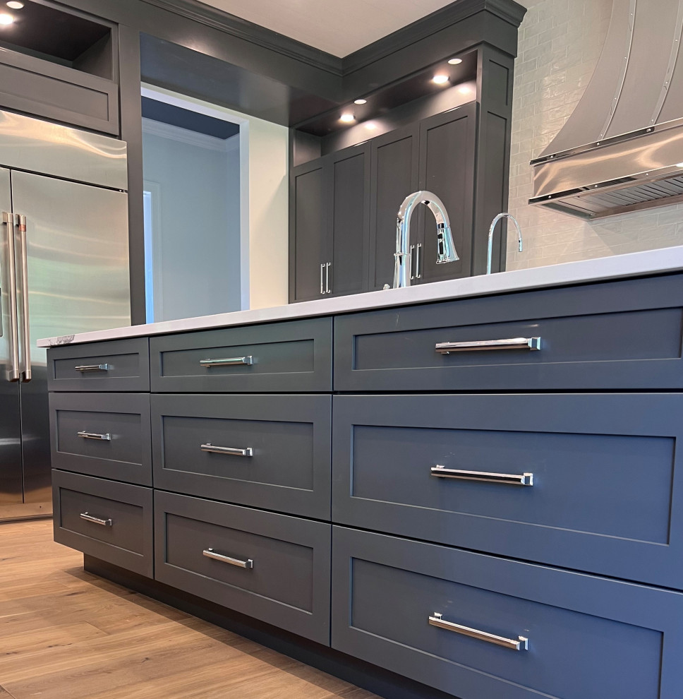 Kitchen - large transitional kitchen idea with an undermount sink, shaker cabinets, gray cabinets, quartz countertops, white backsplash, stainless steel appliances, two islands and white countertops