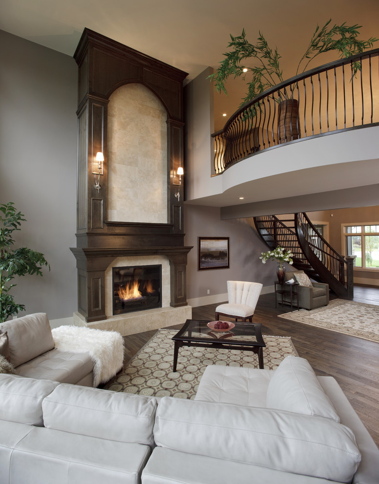 This is an example of a traditional living room in Calgary with grey walls and a standard fireplace.