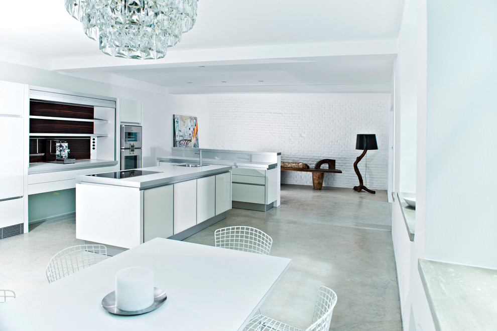 Design ideas for an industrial kitchen in Munich with white cabinets and concrete floors.
