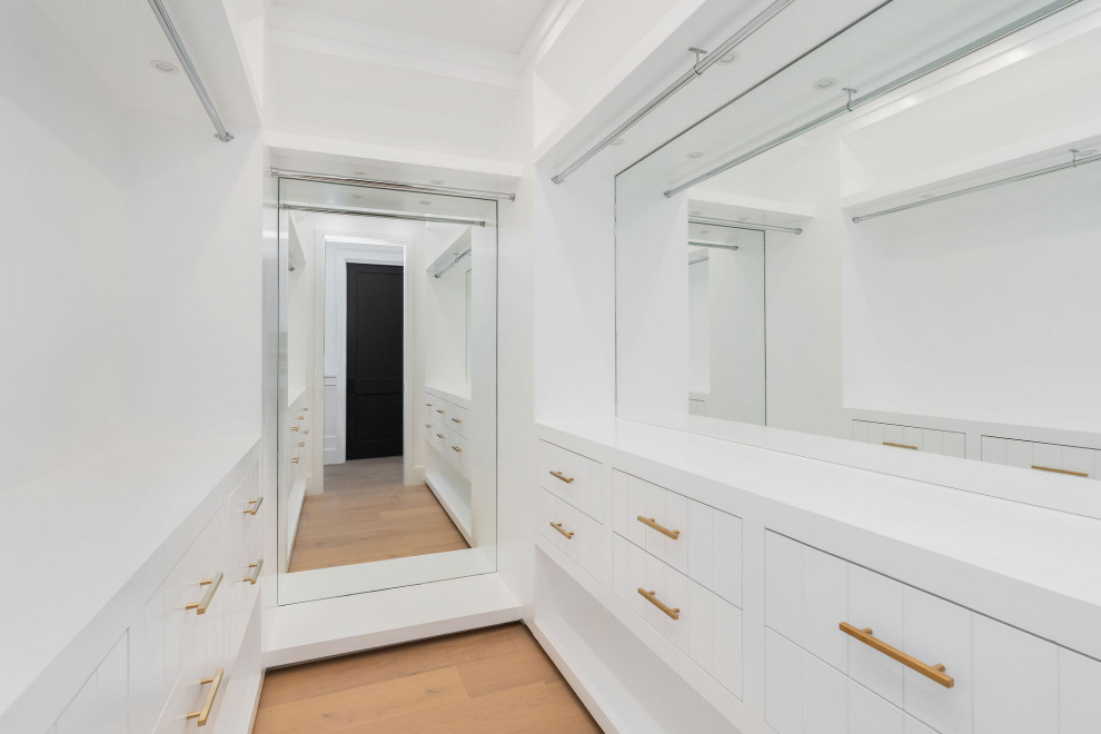 Стильный дизайн: большая гардеробная комната в стиле неоклассика (современная классика) с белыми фасадами - последний тренд