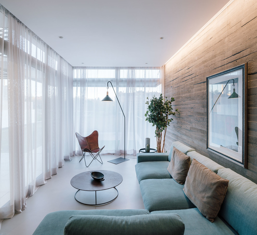 This is an example of a mid-sized contemporary open concept living room in Madrid with concrete floors, grey floor and grey walls.