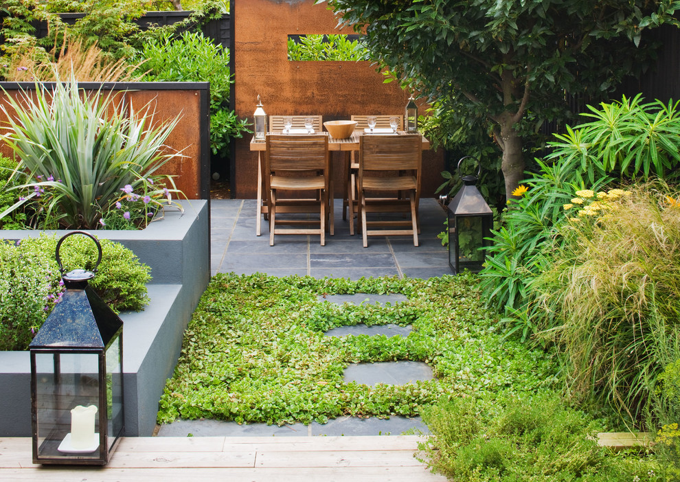 Inspiration for a contemporary backyard patio in London with tile and no cover.