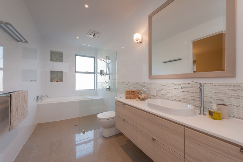 Design ideas for a large contemporary bathroom in Adelaide with raised-panel cabinets, light wood cabinets, a drop-in tub, an open shower, a one-piece toilet, white tile, stone slab, white walls, porcelain floors, a drop-in sink and solid surface benchtops.