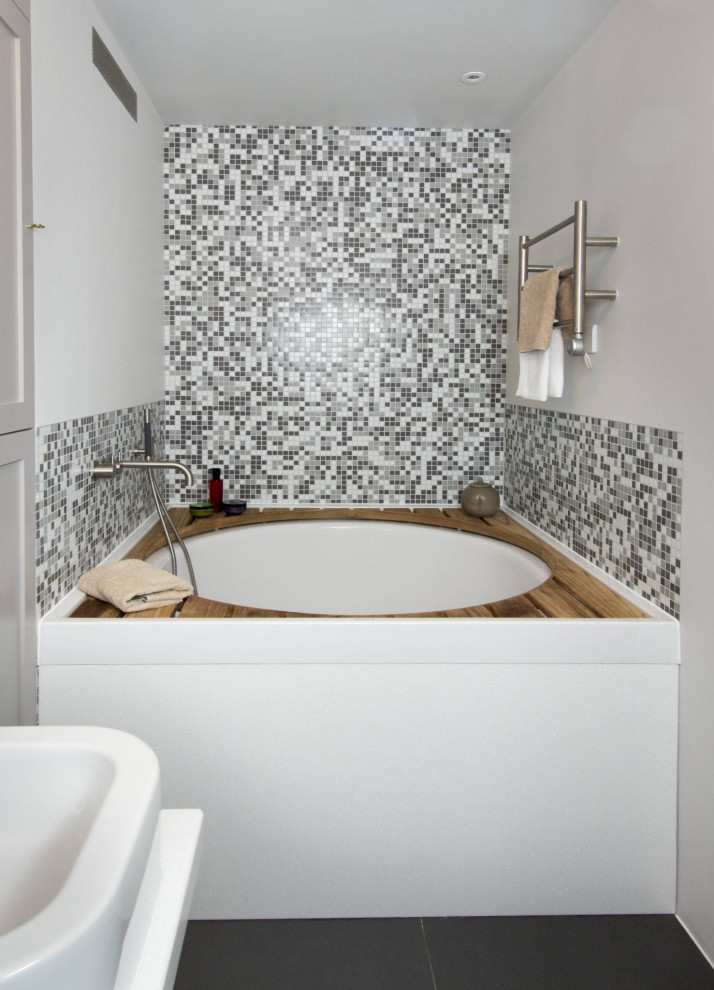 Immagine di una piccola sauna design con vasca idromassaggio, piastrelle grigie, piastrelle a mosaico, pareti grigie, lavabo sospeso, pavimento nero, top bianco, un lavabo, ante in stile shaker, WC sospeso e mobile bagno incassato