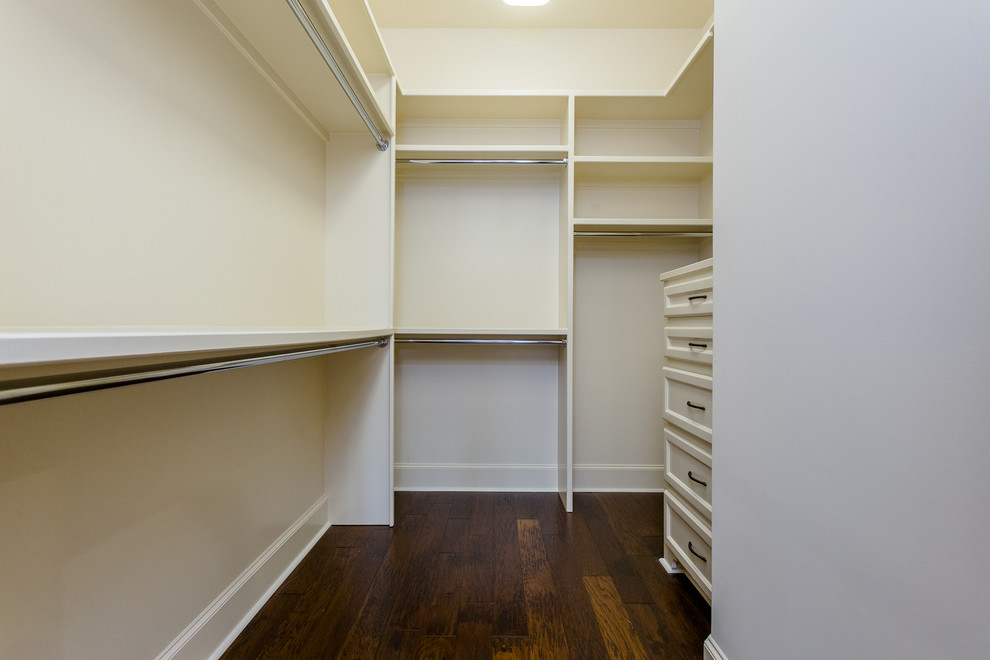 This is an example of a large mediterranean walk-in wardrobe in Houston with recessed-panel cabinets, white cabinets, dark hardwood floors and brown floor.