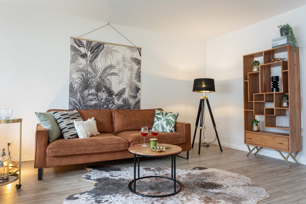 Foto di un soggiorno minimal di medie dimensioni e chiuso con pareti bianche, pavimento in laminato e pavimento marrone