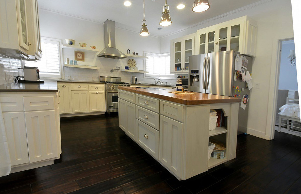 Inspiration for a large transitional u-shaped dark wood floor and brown floor eat-in kitchen remodel in Orange County with an undermount sink, shaker cabinets, white cabinets, wood countertops, white backsplash, subway tile backsplash, stainless steel appliances and an island