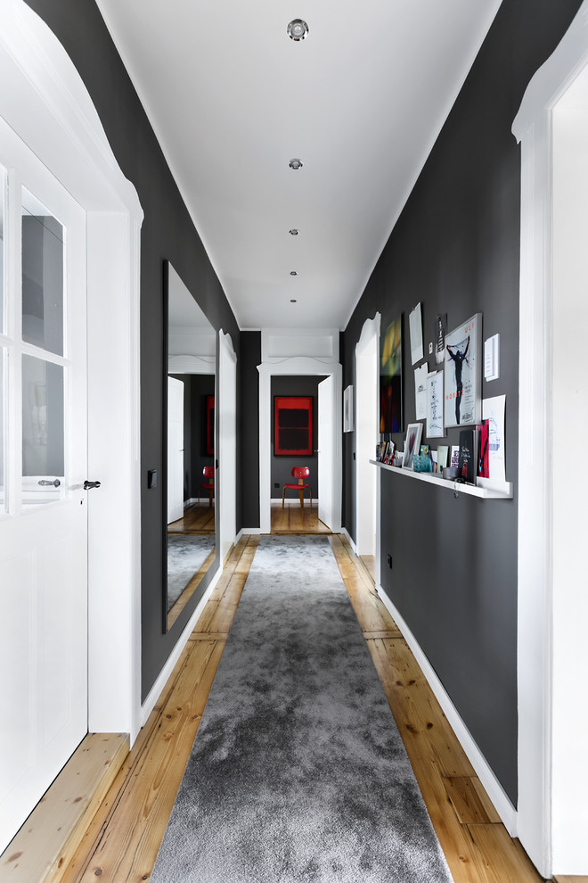 Scandinavian hallway in Hamburg with grey walls, medium hardwood floors and beige floor.