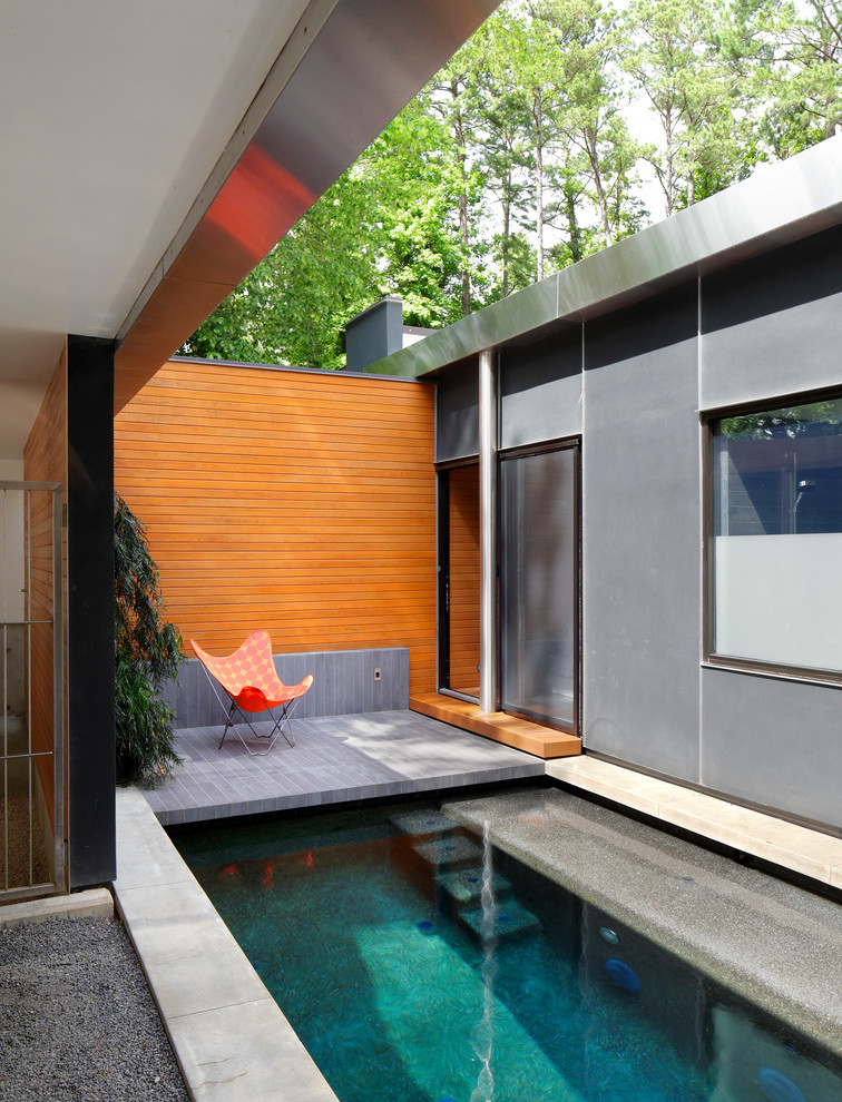 Design ideas for a contemporary courtyard rectangular pool in Raleigh with natural stone pavers.