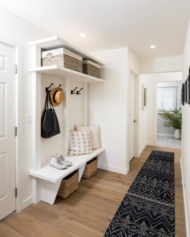 Photo of a mid-sized transitional mudroom in Los Angeles with white walls and light hardwood floors.