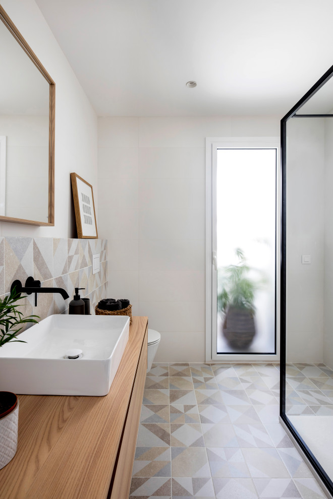 Design ideas for a mid-sized scandinavian master bathroom in Barcelona with flat-panel cabinets, medium wood cabinets, an open shower, a wall-mount toilet, beige tile, ceramic tile, white walls, ceramic floors, a vessel sink, wood benchtops, beige floor, an open shower, white benchtops, a single vanity and a floating vanity.