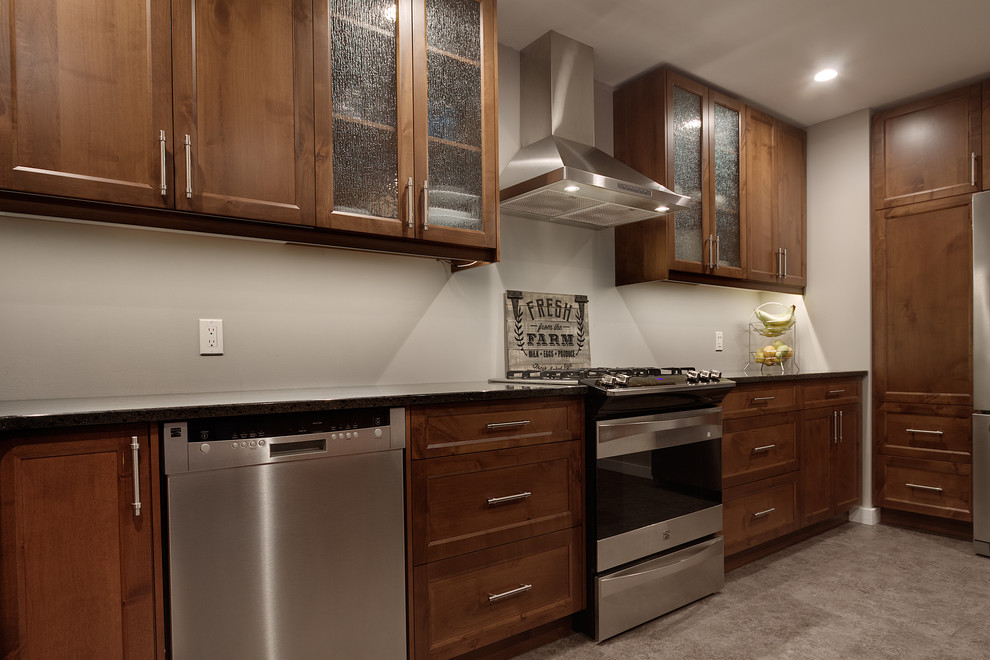 Transitional kitchen photo with shaker cabinets, medium tone wood cabinets, quartz countertops, stainless steel appliances and an island