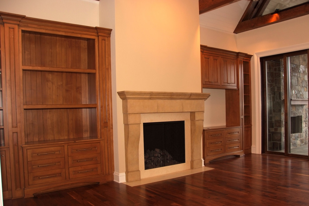 This is an example of a large traditional open concept family room in Portland with medium hardwood floors, a standard fireplace, a built-in media wall, beige walls and brown floor.