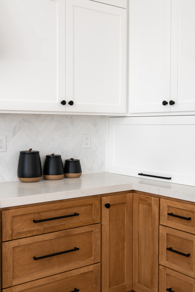 Photo of a small classic l-shaped kitchen in Orange County with a single-bowl sink, shaker cabinets, white cabinets, quartz worktops, white splashback, marble splashback, stainless steel appliances, vinyl flooring, a breakfast bar, brown floors and white worktops.