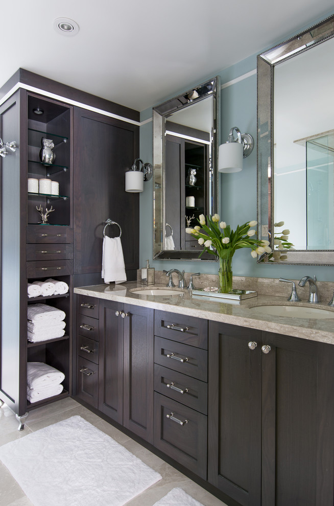 This is an example of a mid-sized traditional bathroom in Toronto with an undermount sink, a drop-in tub, a corner shower, a one-piece toilet, shaker cabinets, medium wood cabinets, multi-coloured tile, stone slab, blue walls and travertine floors.