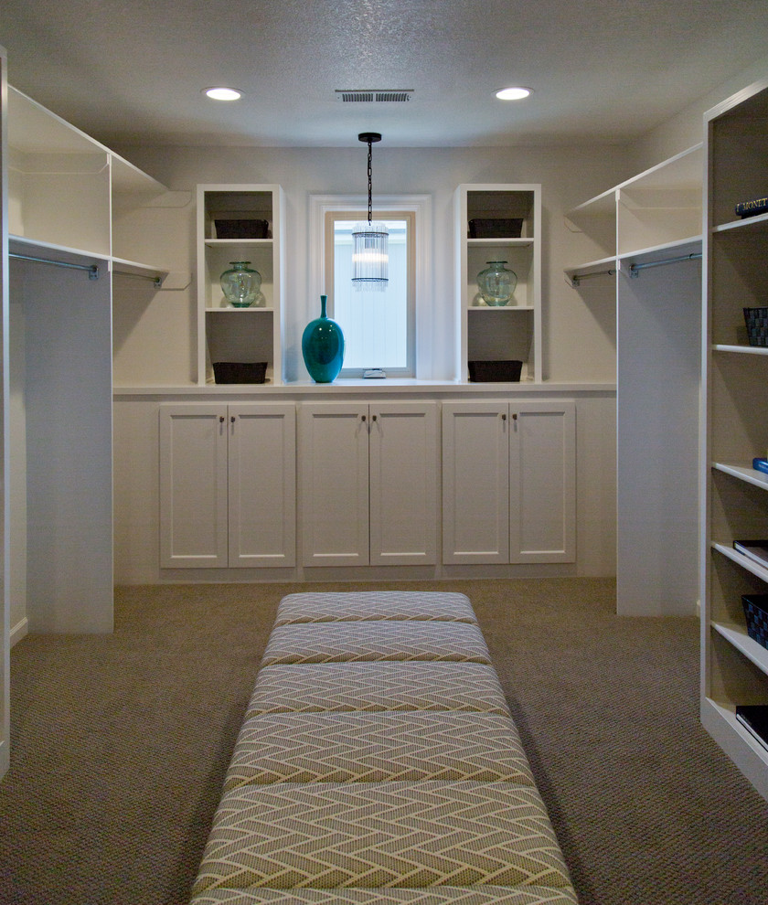 Photo of a large contemporary gender-neutral walk-in wardrobe in Kansas City with recessed-panel cabinets, white cabinets, carpet and beige floor.