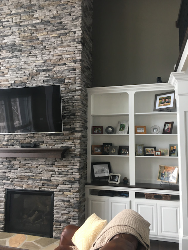 Mid-sized transitional open concept dark wood floor and brown floor living room photo with gray walls, a standard fireplace, a stone fireplace and a wall-mounted tv