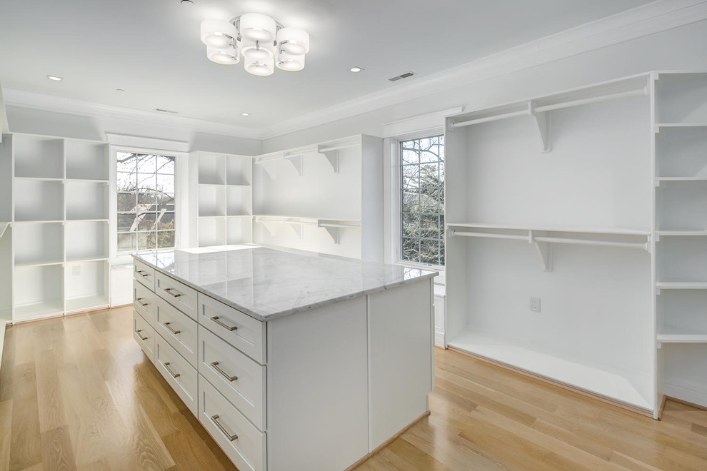 Design ideas for a mid-sized modern walk-in wardrobe in DC Metro with shaker cabinets, white cabinets, light hardwood floors and beige floor.