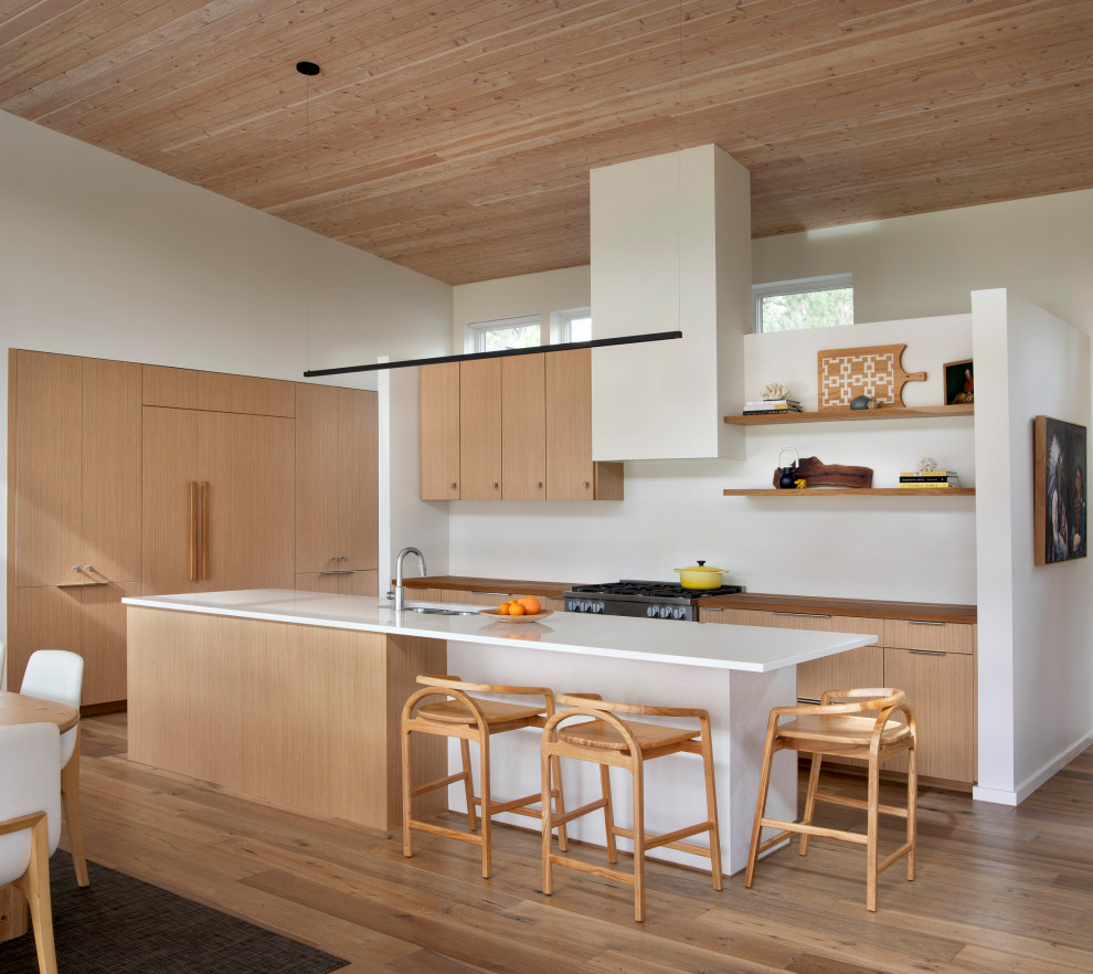 Стильный дизайн: кухня в стиле ретро с обеденным столом, светлыми деревянными фасадами, паркетным полом среднего тона, островом и белой столешницей - последний тренд