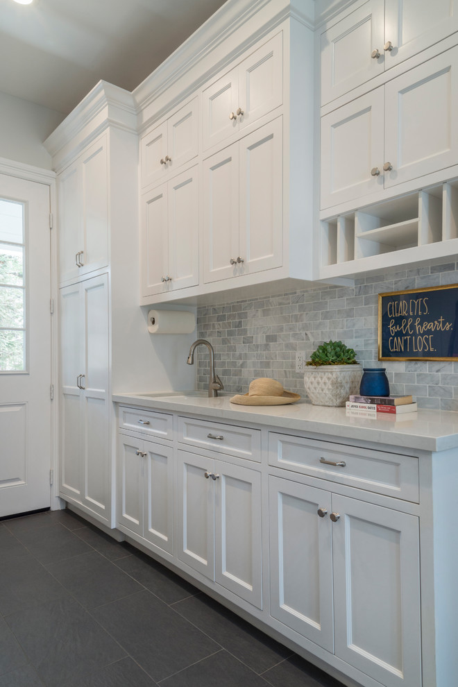 This is an example of a mid-sized contemporary galley utility room in Other with an undermount sink, flat-panel cabinets, white cabinets, granite benchtops, beige walls, marble floors and a side-by-side washer and dryer.