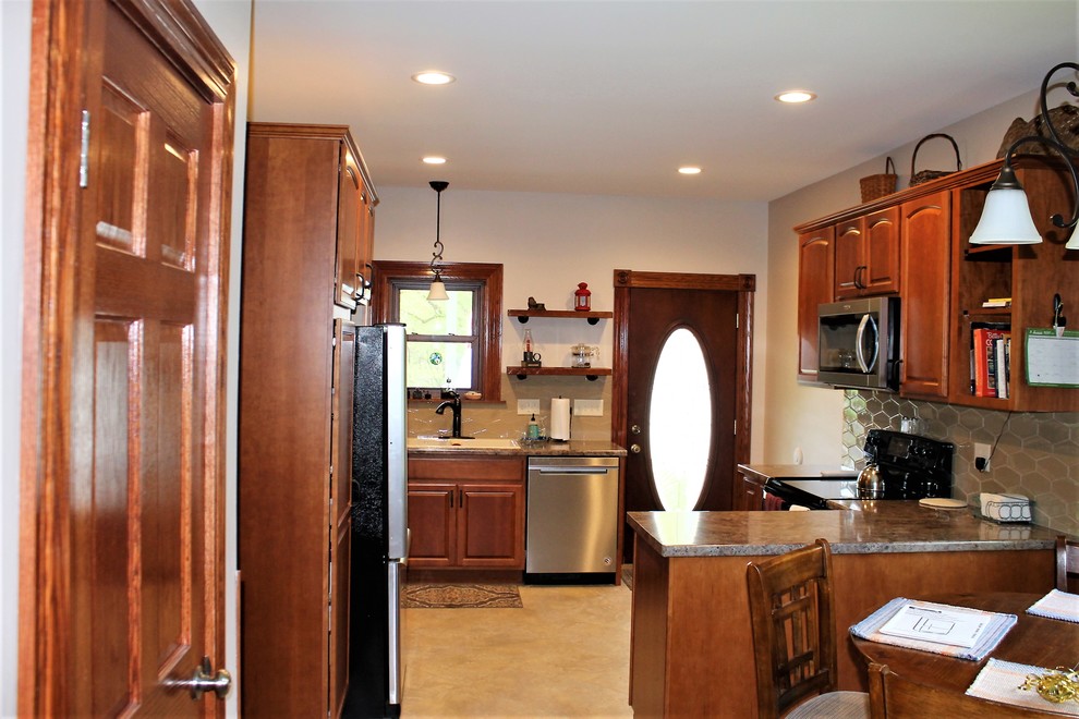 Mid-sized mountain style l-shaped vinyl floor and beige floor eat-in kitchen photo with a farmhouse sink, raised-panel cabinets, medium tone wood cabinets, laminate countertops, beige backsplash, cement tile backsplash, stainless steel appliances, a peninsula and beige countertops