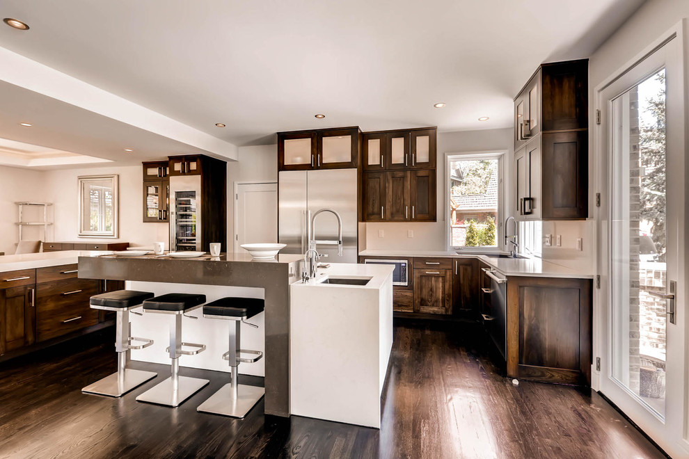 Eat-in kitchen - large transitional l-shaped dark wood floor and brown floor eat-in kitchen idea in Denver with an undermount sink, shaker cabinets, dark wood cabinets, quartz countertops, stainless steel appliances and two islands