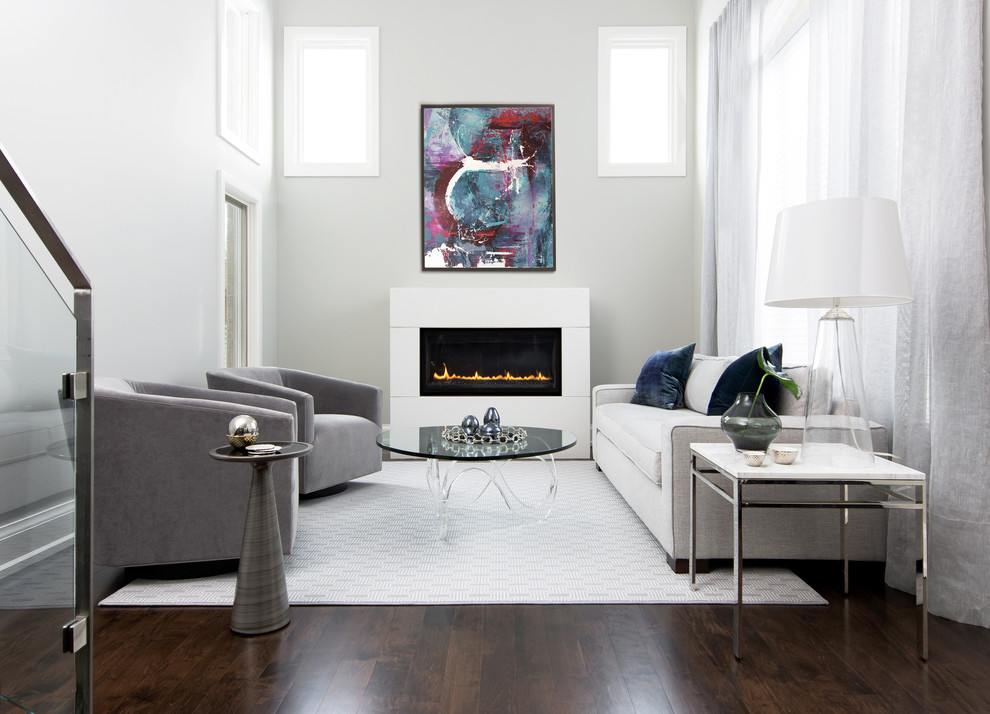 This is an example of a contemporary formal living room in Toronto with grey walls, dark hardwood floors and a standard fireplace.