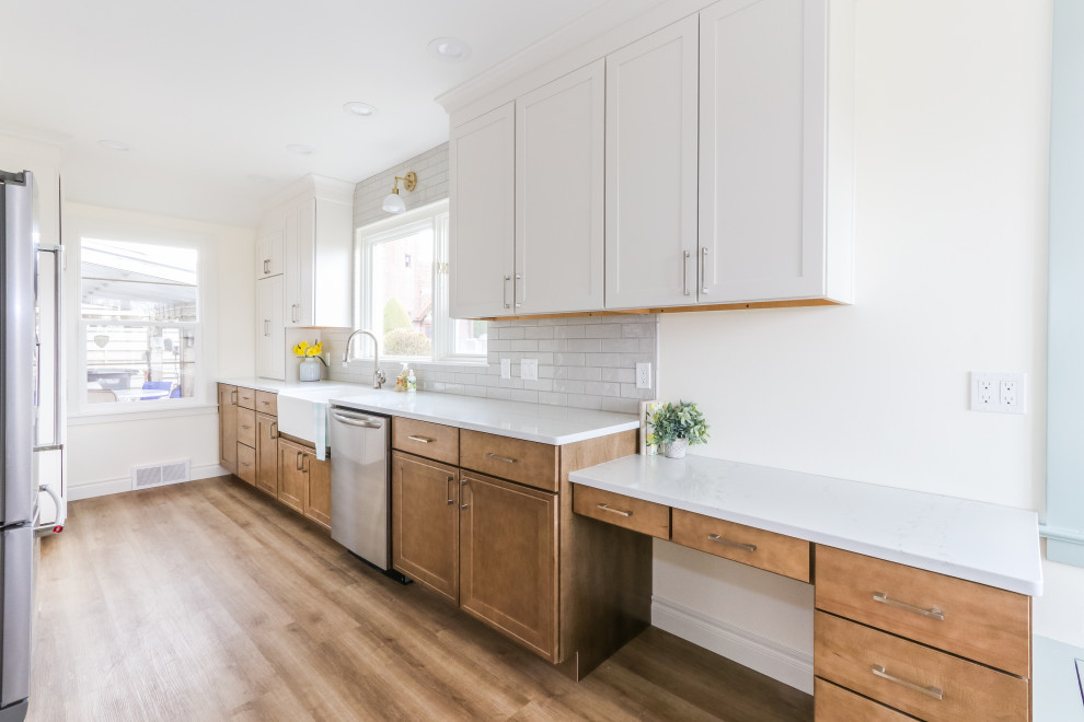 Inspiration for a small country galley separate kitchen in Seattle with a farmhouse sink, shaker cabinets, quartz benchtops, grey splashback, porcelain splashback, stainless steel appliances, vinyl floors and white benchtop.