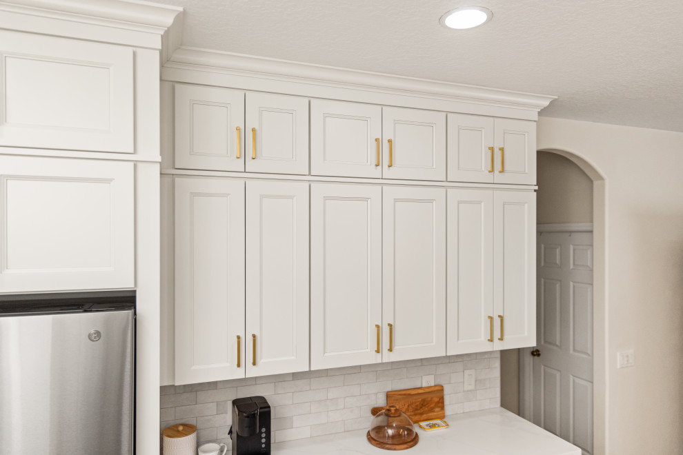 Eat-in kitchen - small transitional l-shaped light wood floor and multicolored floor eat-in kitchen idea in Tampa with an undermount sink, shaker cabinets, beige cabinets, quartzite countertops, beige backsplash, porcelain backsplash, stainless steel appliances, a peninsula and white countertops