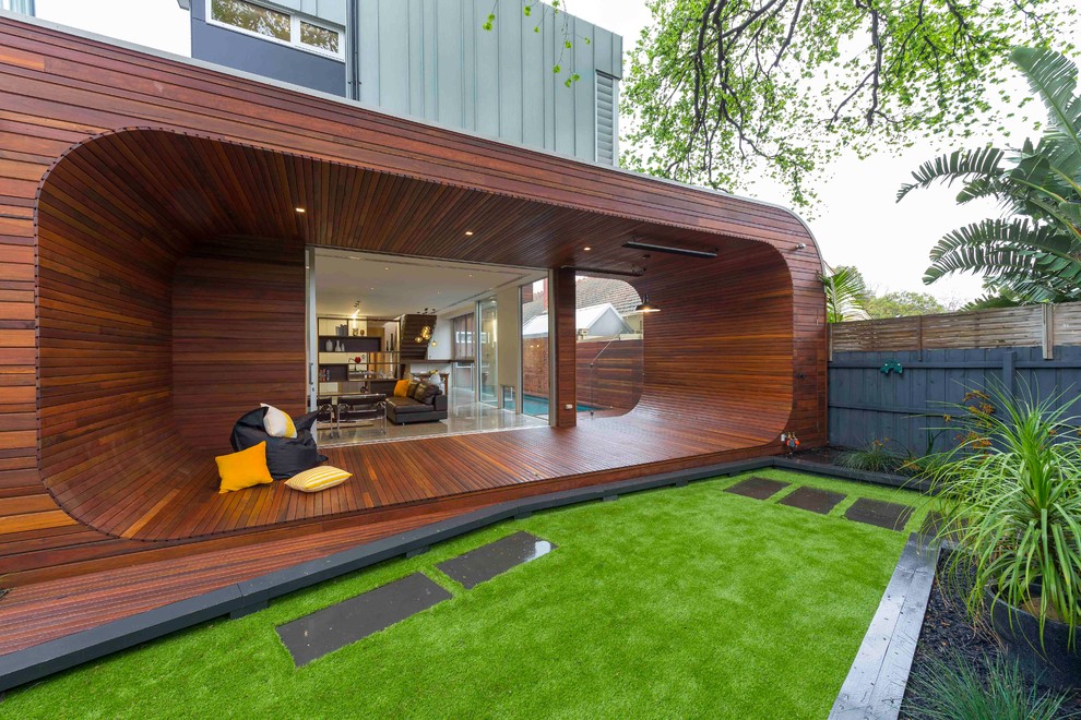 This is an example of a contemporary backyard deck in Melbourne with a roof extension.