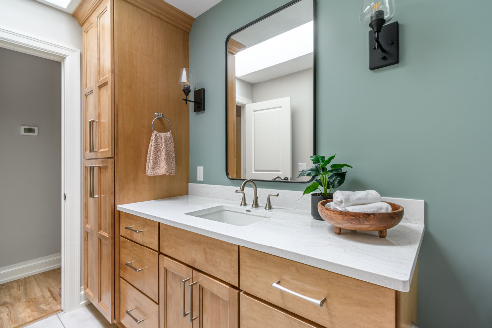 Bathroom - transitional ceramic tile, white floor and single-sink bathroom idea in Minneapolis with shaker cabinets, light wood cabinets, green walls, an undermount sink, quartz countertops, white countertops and a built-in vanity