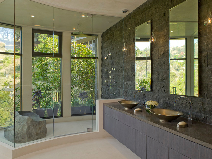 Design ideas for a contemporary bathroom in Los Angeles with a vessel sink, flat-panel cabinets, grey cabinets, engineered quartz benchtops, a freestanding tub, a double shower, a one-piece toilet, gray tile and stone tile.