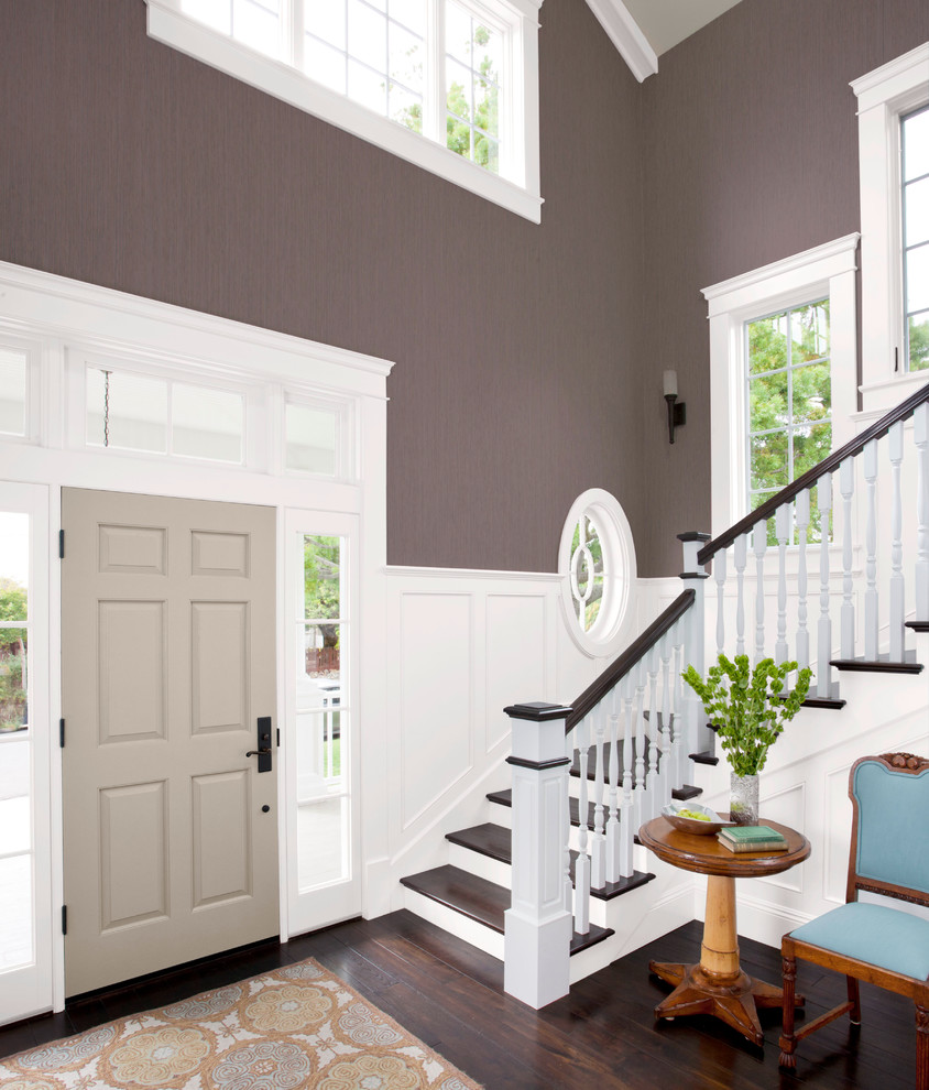 This is an example of a large transitional foyer in Charlotte with brown walls, dark hardwood floors, a single front door and a gray front door.
