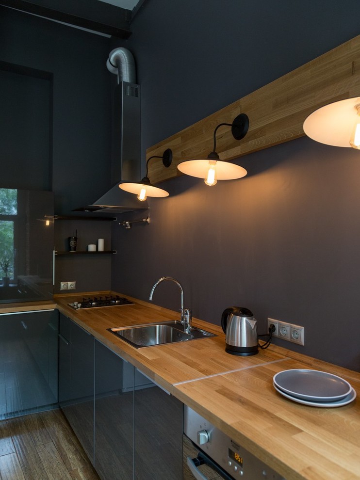 Photo of a mid-sized industrial l-shaped eat-in kitchen in Moscow with a single-bowl sink, flat-panel cabinets, grey cabinets, wood benchtops, grey splashback, stainless steel appliances, bamboo floors and no island.