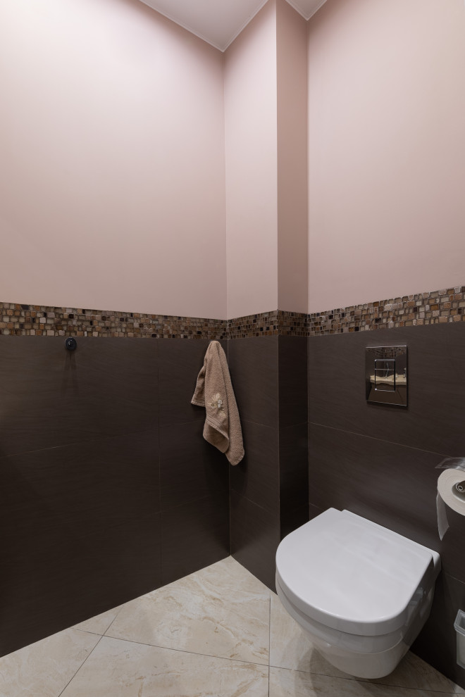 Источник вдохновения для домашнего уюта: туалет среднего размера в стиле неоклассика (современная классика) с плоскими фасадами, бежевыми фасадами, инсталляцией, коричневой плиткой, керамической плиткой, коричневыми стенами, полом из керамогранита, монолитной раковиной, столешницей из искусственного камня, коричневым полом, бежевой столешницей, встроенной тумбой и балками на потолке