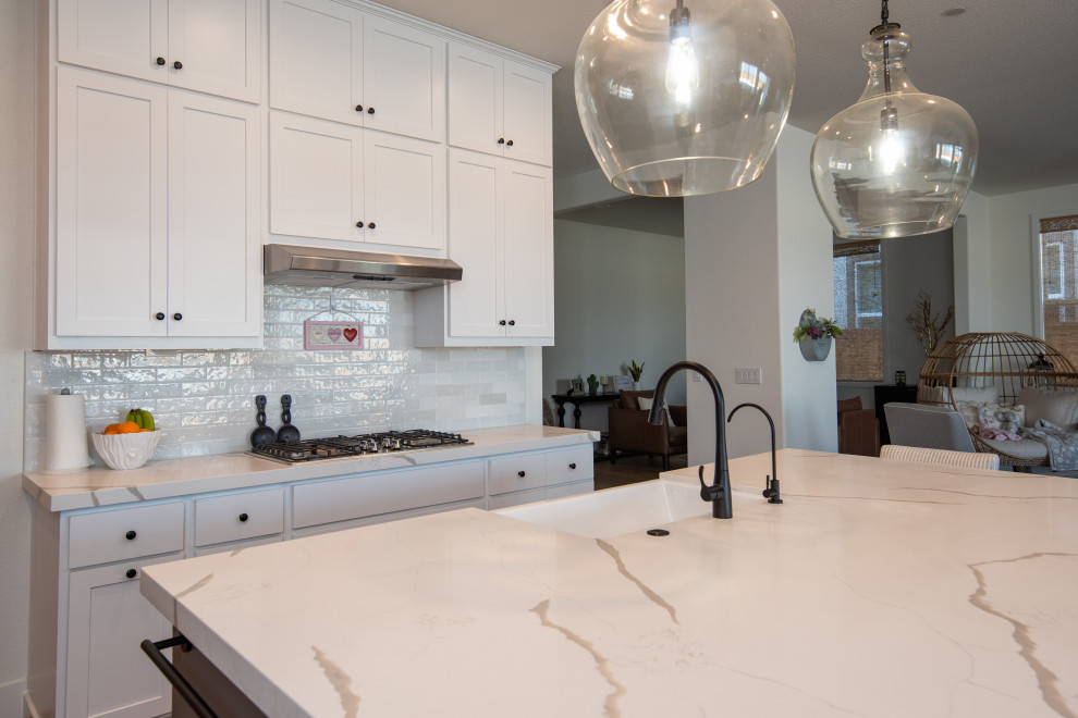 This is an example of a contemporary eat-in kitchen in Sacramento with a farmhouse sink, quartz benchtops, white splashback, ceramic splashback, with island and white benchtop.