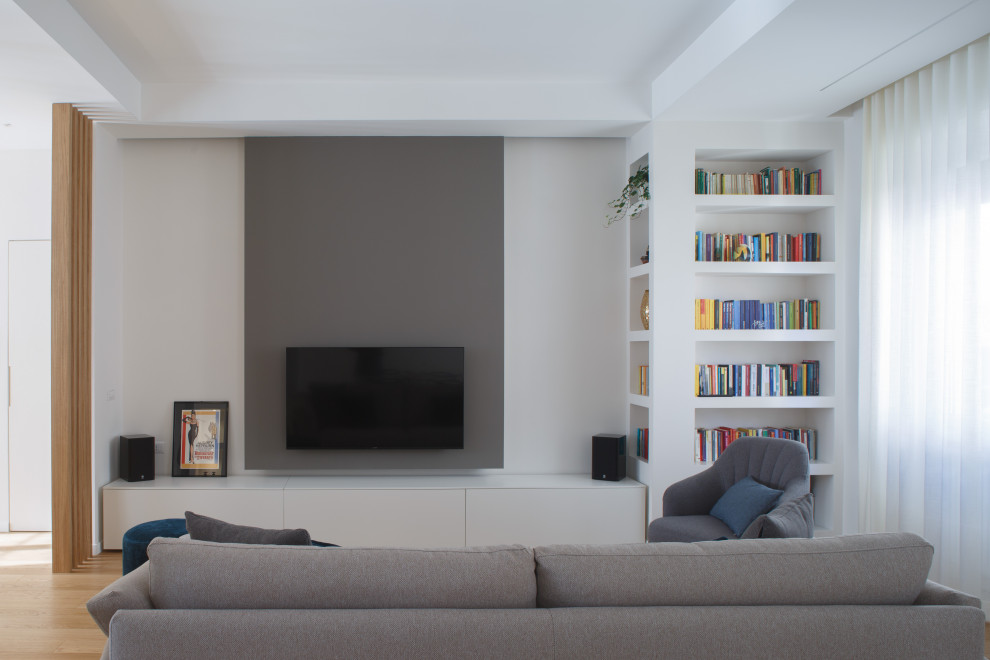 Modelo de biblioteca en casa abierta minimalista de tamaño medio con televisor colgado en la pared