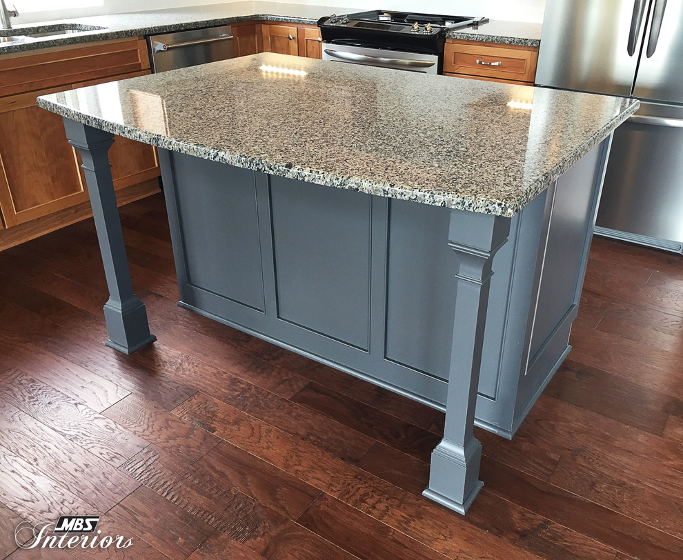 Eat-in kitchen - mid-sized transitional l-shaped dark wood floor and brown floor eat-in kitchen idea with an undermount sink, recessed-panel cabinets, medium tone wood cabinets, granite countertops, white backsplash, ceramic backsplash, stainless steel appliances and an island
