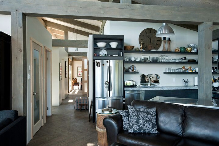 Example of a large mountain style galley light wood floor open concept kitchen design in Boston with an undermount sink, shaker cabinets, dark wood cabinets, solid surface countertops, stainless steel appliances and an island