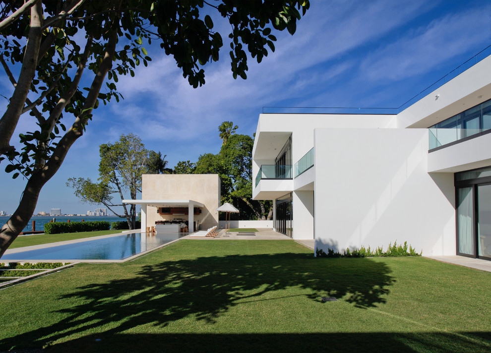 Design ideas for a large modern two-storey brick white house exterior in Miami with a flat roof.