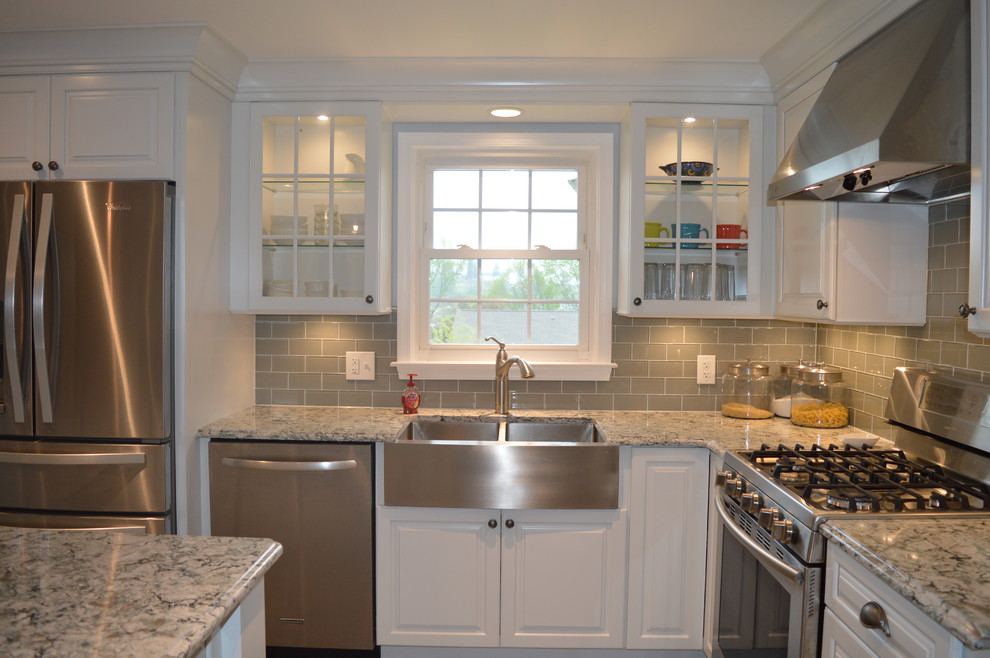 Inspiration for a large transitional u-shaped ceramic tile and gray floor enclosed kitchen remodel with a farmhouse sink, raised-panel cabinets, white cabinets, quartz countertops, gray backsplash, glass tile backsplash, stainless steel appliances and an island