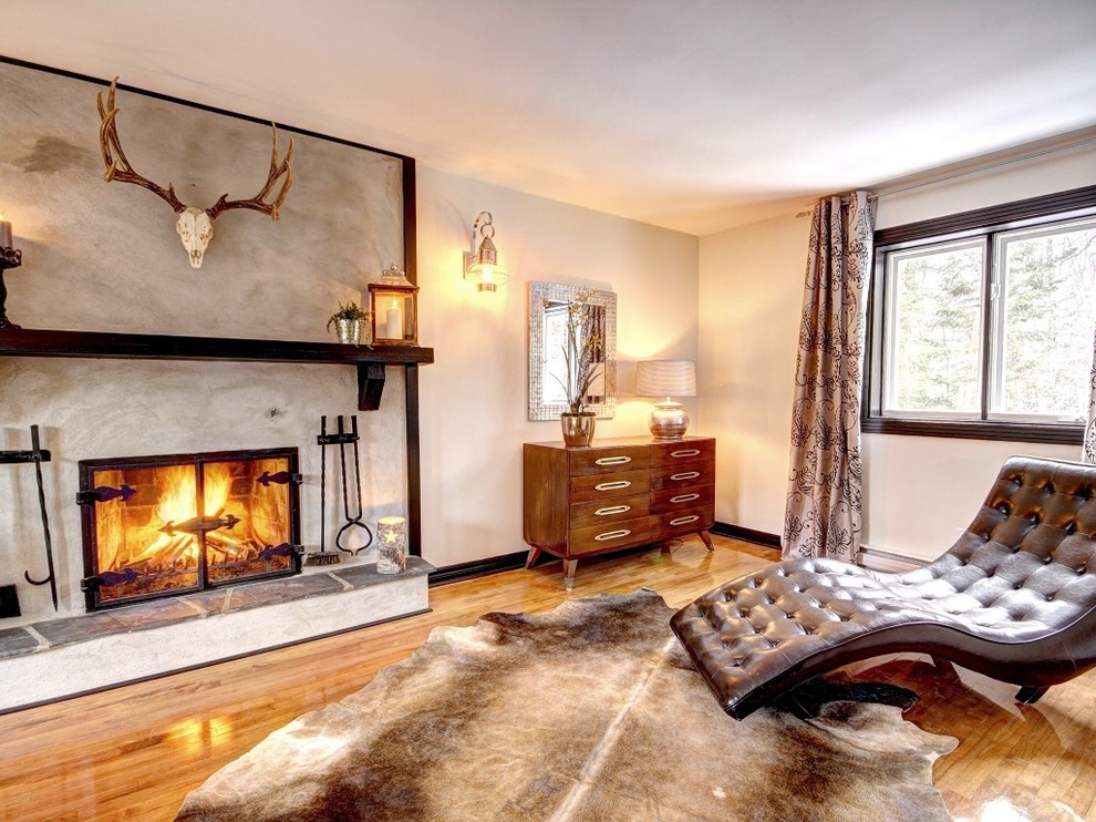 Design ideas for a large country master bedroom in Montreal with white walls, light hardwood floors, a standard fireplace and a concrete fireplace surround.
