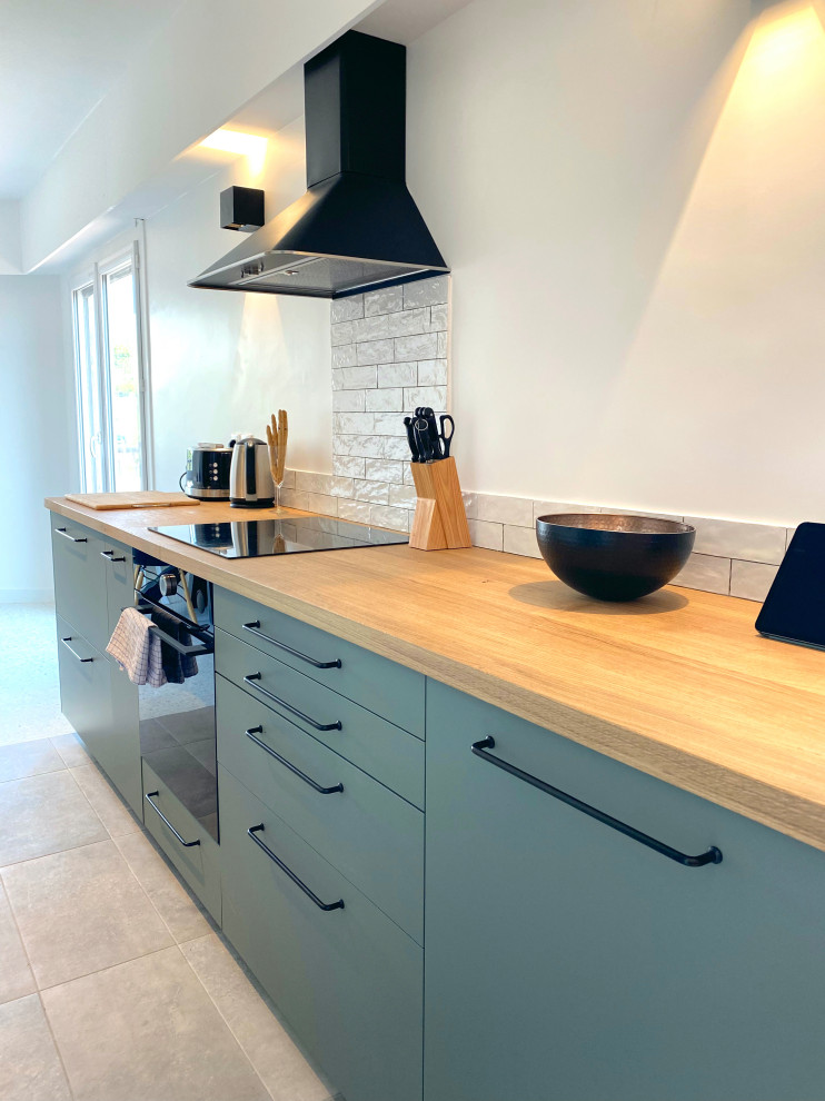 Design ideas for a small contemporary galley open plan kitchen in Nice with an undermount sink, green cabinets, wood benchtops, white splashback, ceramic splashback, ceramic floors, no island, grey floor and brown benchtop.