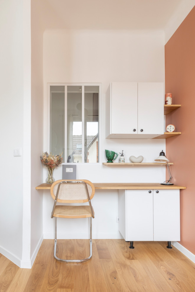 Idéer för ett mellanstort minimalistiskt arbetsrum, med rosa väggar och ljust trägolv