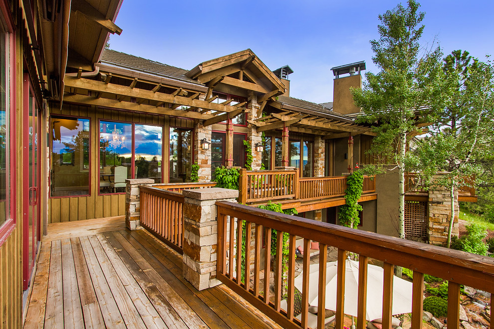 This is an example of a large country deck in Denver with a pergola.