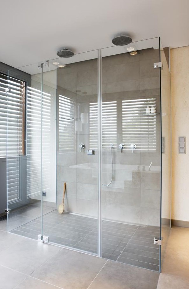 Large contemporary bathroom in Nuremberg with a double shower, gray tile, stone tile and beige walls.